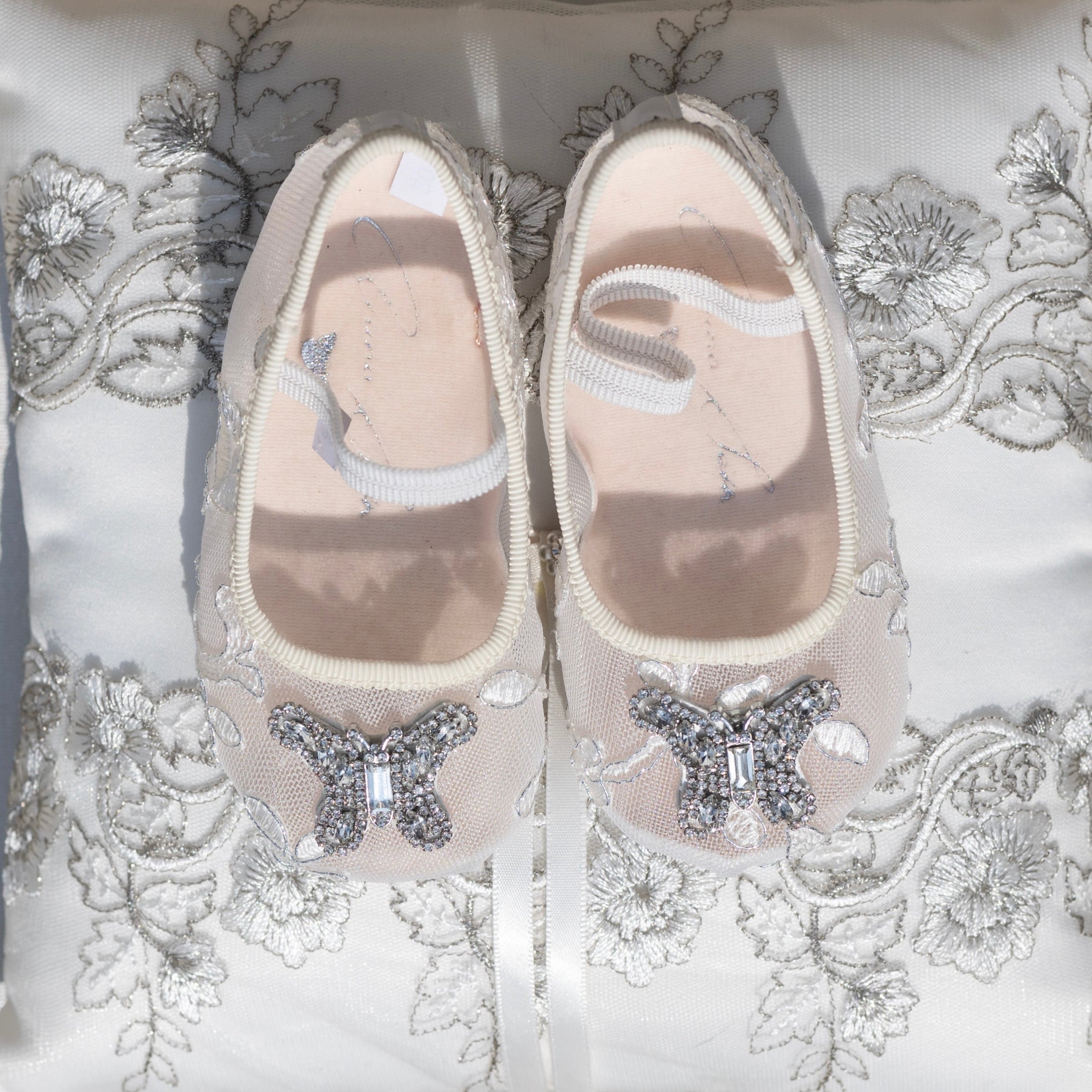 Ivory lace baby shoes perfect for flower girls, handcrafted with delicate lace and satin for luxury weddings and special occasions.